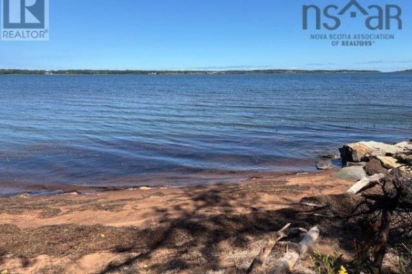 Aerial view of a wooded lot with a small white house and a large body of water. - Lot 86-4 Fox Harbour South Road, North Wallace