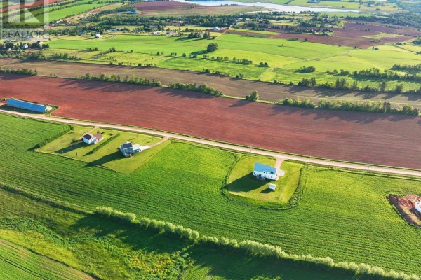 Drone view of rural landscape with red and green agricultural fields, houses, and a blue structure. - Lot 9 Scenic View Road, Long Creek