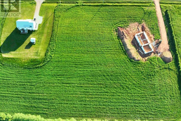 Top-down view of a green field with a house and a concrete building foundation excavation. - Lot 9 Scenic View Road, Long Creek