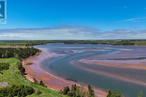 Aerial view of a wide river estuary with red sandbanks and green tree-lined shores under a bright blue sky. - Lot Aitken Lane, Bay Fortune