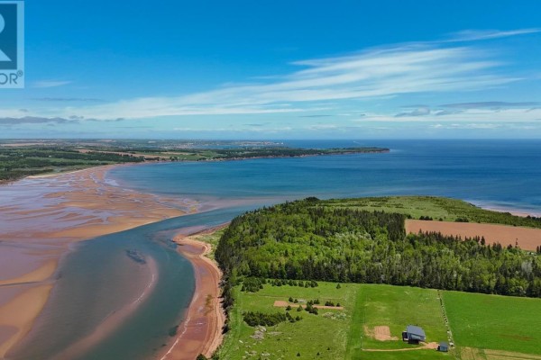 Expansive aerial view of a coastline with a river mouth, green fields, trees, and the blue ocean meeting the horizon. - Lot Aitken Lane, Bay Fortune