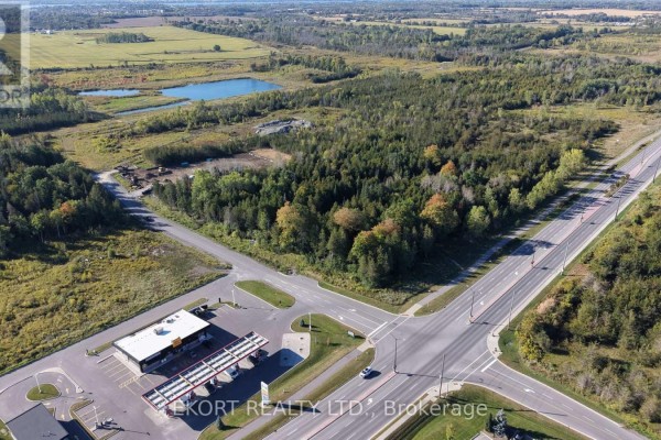 Aerial view of a rural intersection with a gas station and wooded lots, near agricultural fields. - Lot B & C Jenland Way S, Belleville