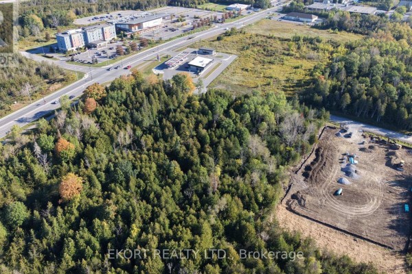 Aerial view of wooded lots with cleared construction site and nearby commercial buildings. - Lot B & C Jenland Way S, Belleville