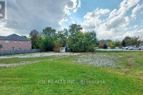 Grassy lot with a pathway, surrounded by trees and residential properties. - Lot C - 0 Melbourne Drive, Richmond Hill