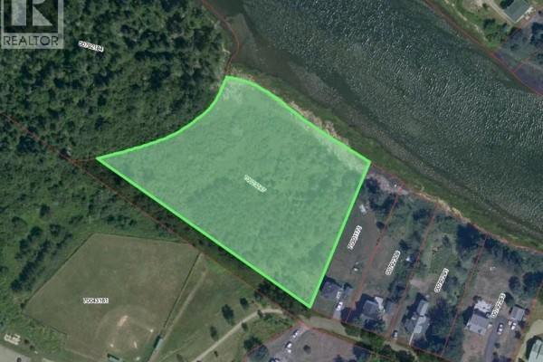Aerial view highlighting a large, irregularly shaped lot bordered by trees and water. - Lot Church Street, Port Elgin