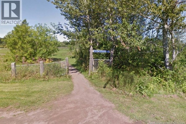 Dirt path entrance to a park area with a chain-link gate and signage. - Lot Church Street, Port Elgin