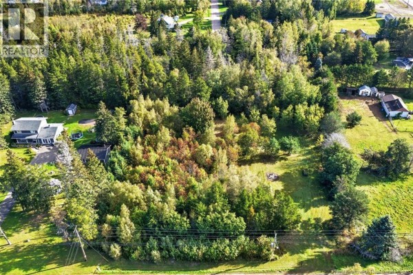 Overhead view showing a wooded lot with some cleared areas and nearby homes. - Lot De La Breche Road, Grand Barachois