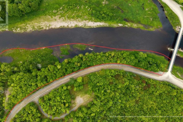 Close-up aerial view of the river's edge, showing vegetation and a nearby road. - Lot Lead Mines Road, Glenelg