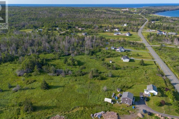 Aerial view of rural landscape with houses, fields, trees, and a road. - Lot Mines Drive Road, Port Morien