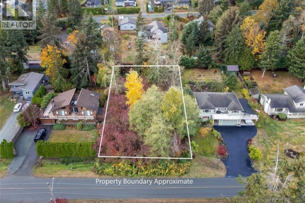 Aerial shot of the property with nearby houses and trees, showcasing the neighborhood layout. - Lot N Kilmarnock Dr, Courtenay