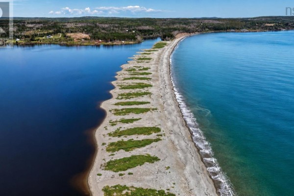 Aerial view of a long, narrow sandy land bridge separating a dark lake from a turquoise ocean. - Lot No 327 Highway, Gabarus