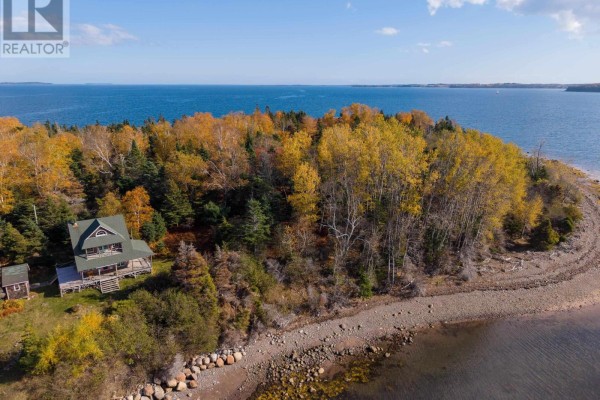 Aerial view of the property featuring a house, trees with fall colors, and a shoreline with rocks. - Lot Rous Island, Indian Point