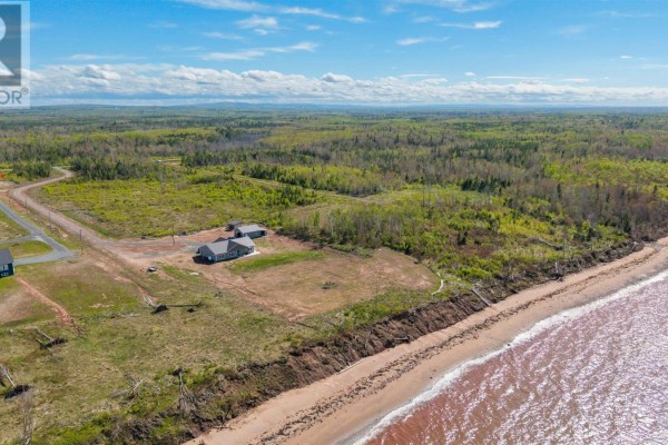 Drone view of a waterfront lot with a house, garage, and coastal landscape. - Lot Shore Road, Waterside