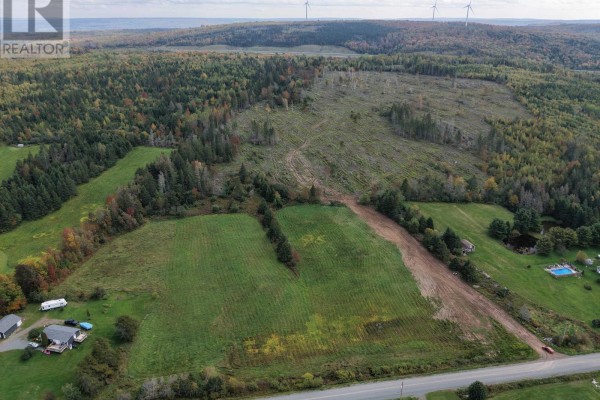 Aerial view of a cleared area in a wooded landscape with wind turbines on the horizon. - Lot Tanner Hill Road, Limerock