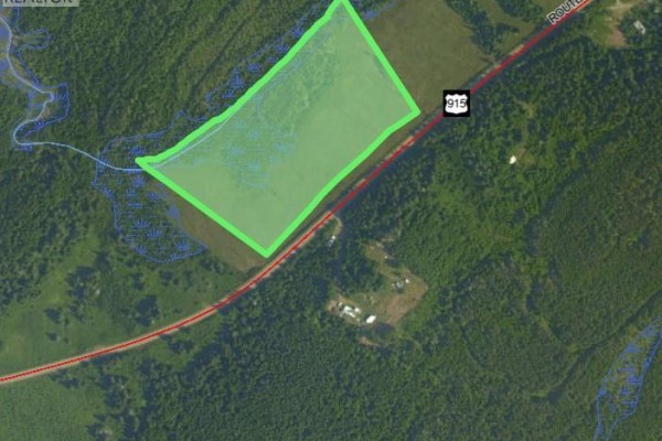 Satellite view highlighting a green outlined lot next to a road and surrounded by trees. - Lot Waterside Road, Cape Enrage