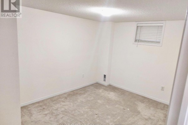 Small carpeted basement room with a window and beige walls. - Lower - 11 Catherine Drive, Barrie