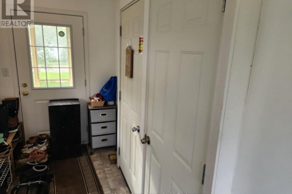 View of a small entryway with a shoe rack, storage drawers, and a back door. - Lower - 12 Shannon Street, Orillia