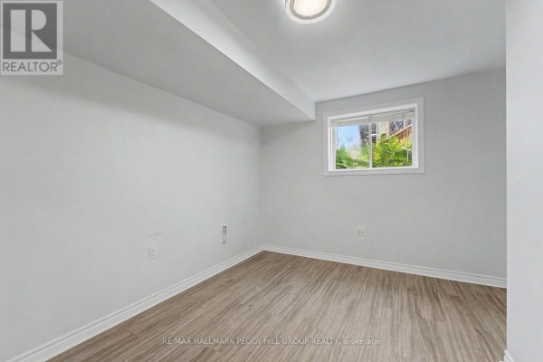 A small room with a window, light wood floors, and white walls. - Lower - 148 Livingstone Street E, Barrie