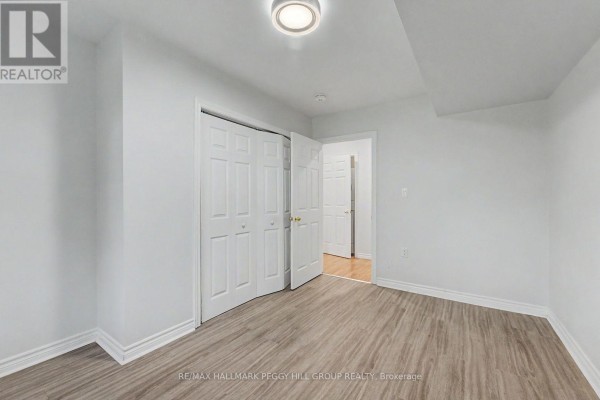 A white room with light wood floors, a large closet, and a doorway to a hallway. - Lower - 148 Livingstone Street E, Barrie