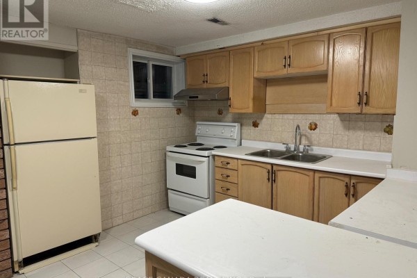 A small kitchen with light wood cabinets, a white stove, double sink, and a beige refrigerator. - Lower - 162 Jackman Crescent, Vaughan