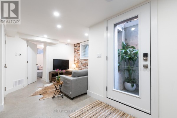 Entrance door with a view to a small outdoor area with plants. - Lower - 180 Maria Street, Toronto