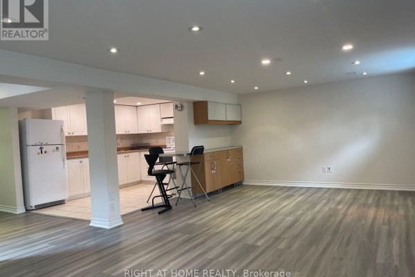 View of a finished basement, kitchenette, and bar area with pendant lights. - Lower - 191 Princess Avenue, Toronto