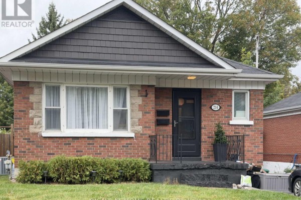 Exterior front view of a brick house with a dark front door and stone accents. - Lower - 214 Greenwood Avenue, Oshawa