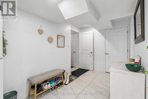 Interior hallway with white walls, tiled floor, bench with shoe storage, and white doors. - Lower - 23 Cyprus Glen, East Gwillimbury