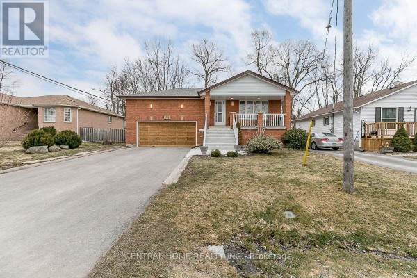 Front view of a red brick bungalow with a driveway, lawn, and neighboring houses. - Lower - 299 Lakeview Boulevard, Georgina