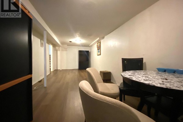 Basement living space with dining area and chairs in the foreground. - Lower - 3320 Grechen Road, Mississauga