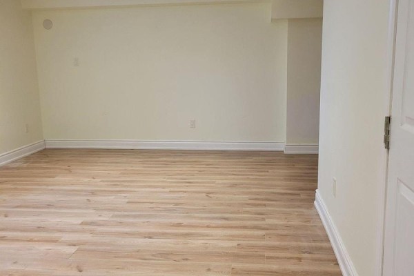Corner of a room with light yellow walls, baseboards, and a large mirrored closet. - Lower - 42 Ambleside Crescent, Markham