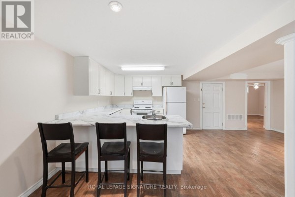 Kitchen island with marble countertop and three bar stools in a basement suite. - Lower - 531 Rodd Avenue, Pickering