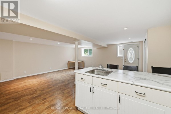 Basement living area with a window, doorway, and kitchen island with sink in foreground. - Lower - 531 Rodd Avenue, Pickering