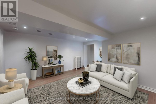 Living room with light wood floors, light grey walls, and a large sectional sofa facing a media console. - Lower - 553 Euclid Avenue, Toronto
