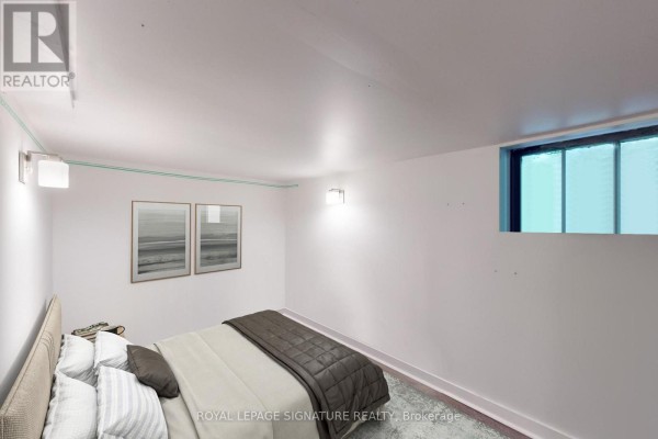 Bedroom with a queen-sized bed, light grey walls, and a small window. - Lower - 553 Euclid Avenue, Toronto