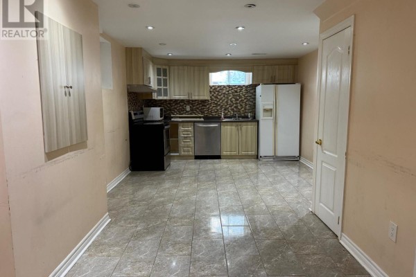 A spacious basement kitchen with light wood cabinets and tile flooring. - Lower - 5689 Sidmouth Street, Mississauga