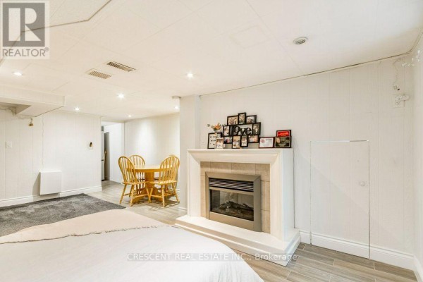 Fireplace with mantelpiece and dining area in the bedroom. - Lower - 603 Saint Clarens Avenue, Toronto