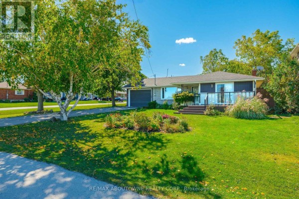 Wider shot of the bungalow exterior with a bright blue sky and surrounding greenery. - Lower - 71 Lakeside Drive, Grimsby