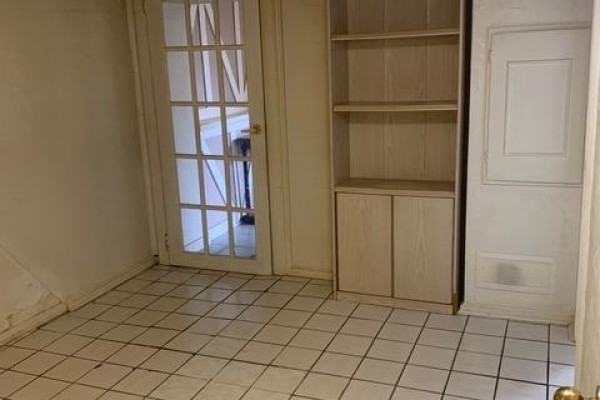 Room with white checkered tile floor, a glass-paned door, and built-in shelving unit. - Lower - 730 Logan Avenue, Toronto