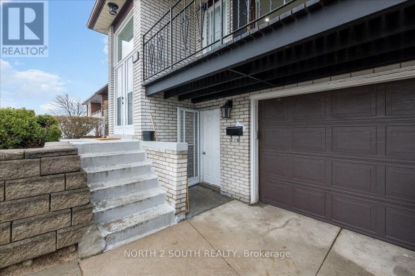 Exterior view showing concrete steps leading to a lower-level entrance and garage door. - Lower - 7520 Langworthy Drive, Mississauga