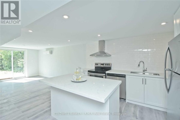 Open concept basement kitchen with white subway tile backsplash, stainless steel appliances, and island. - Lower - 760 Ashley Court, Oshawa