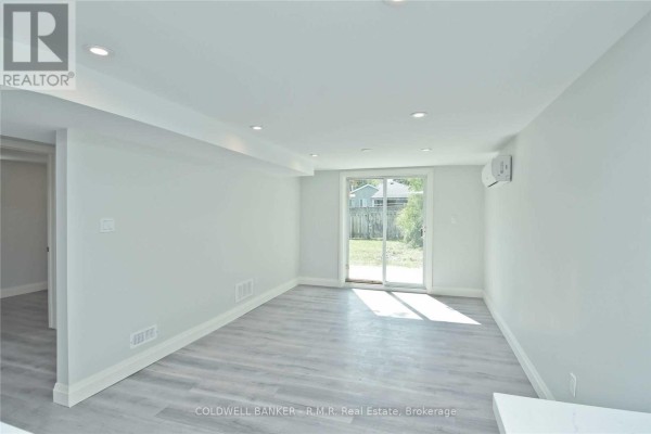 Living area in a basement with a sliding glass door leading to the backyard. - Lower - 760 Ashley Court, Oshawa