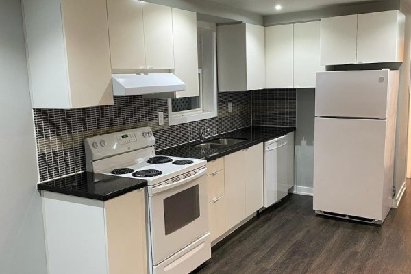 White kitchen cabinets, dark speckled backsplash, white oven, and a white refrigerator. - Lower - 78 Cavell Avenue, Toronto