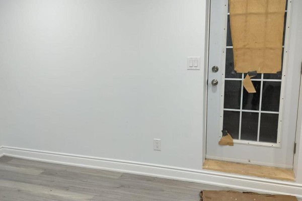 Interior of a room with white walls, baseboards, and a glass door covered by paper. - Lower - 852 Mcnair Circle, Milton