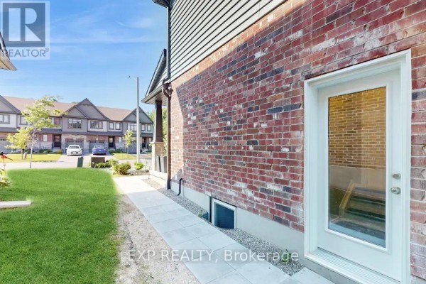 Side view of the house showing a brick exterior wall, a walk-way, and a glass door leading outside. - Lower - 967 Wright Drive, Midland