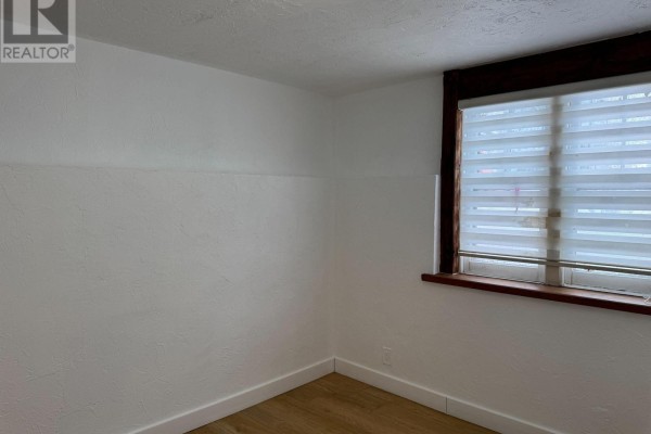Bedroom with white walls, wood-look flooring, and a window with horizontal blinds. - Lower 2 - 233 Ellerslie Avenue, Toronto