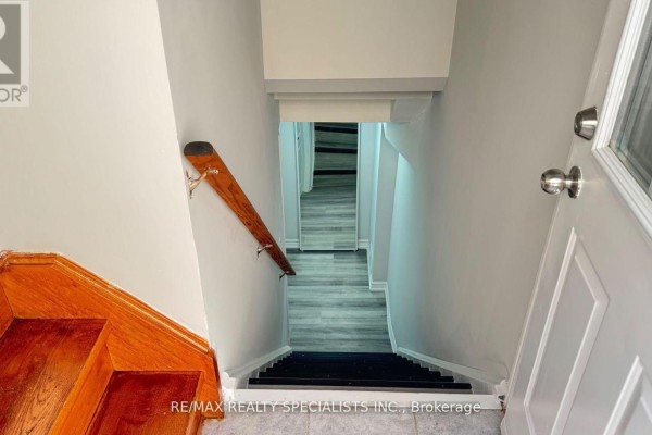 Top-down view of a staircase with wooden banister, grey walls, and laminate flooring below. - Lower 2-b - 3 Lennon Trail, Brampton