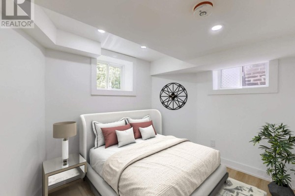 Bedroom with a queen-size bed, white walls, a nightstand with a lamp, and two small windows. - Lower F - 250 Major Street, Toronto