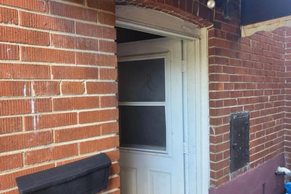 Close-up of a white door on a red brick exterior, with a mailbox below. - Lower Level - 15 North Bonnington Avenue, Toronto