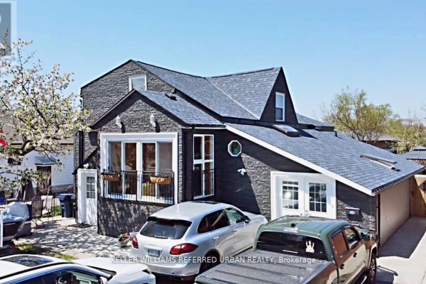Front exterior of the house with cars parked in the driveway and a boat on a trailer. - Lower Level - 6 Elmhurst Drive, Toronto